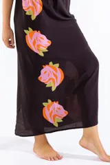Vestido largo negro con cuello halter y estampado lateral de cabezas de tigre en tonos rosados y naranjas con hojas verdes.