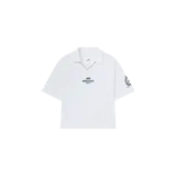 Remera polo de manga corta blanca de la marca Eme Studios, con cuello en V, detalles de líneas en el escote y estampa en el pecho y manga.
