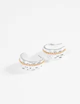 Aros tipo argolla de metal plateado con textura martillada y una hilera de pequeñas cuentas doradas en el centro.