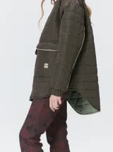 Campera reversible capitoneada con cierre frontal. Un lado es de color negro y el otro es de color beige, ambos con diseño acolchado. Cuenta con cuello redondo, mangas largas y bolsillos laterales.