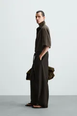 Camisa de corte relajado confeccionada en tejido con mezcla de modal, con cuello solapa, manga corta y cierre frontal de botones.