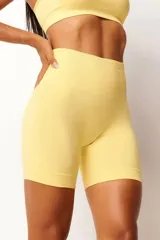 Short deportivo color amarillo, de tiro alto y corte ajustado. Confeccionado con tecnología seamless y textura acanalada en la cintura.