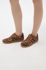 Zapatillas urbanas con estampado animal print de leopardo, cordones al tono y detalles de franjas laterales en color negro. Presentan suela de goma color caramelo y cuello acolchado.