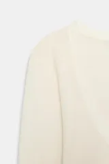 Top de punto extrafino color celeste, con escote redondo y manga larga.