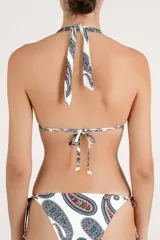 Top de bikini halter con estampado paisley en tonos azules, rojos y marrones sobre fondo blanco. Cuenta con tiras para atar al cuello y en la espalda, y detalle de argolla metálica en el centro con cordones ajustables terminados en terminales metálicas.