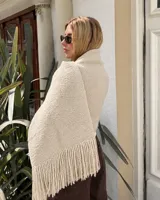 Pashmina de tejido texturizado en color beige, con flecos en los extremos.