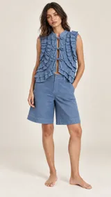 Bermuda de mezclilla azul con bolsillos traseros ribeteados, costuras en contraste y etiqueta de cuero con la marca en la parte posterior.