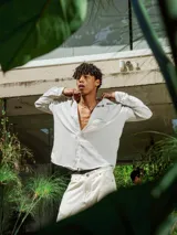 Camisa de lino con diseño de cuadrillé en tonos blanco y beige, de manga larga y cuello clásico. Presenta una pequeña estampa en el pecho y una estampa en la espalda, con un calce holgado y relajado.