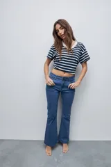 Jean flare de tiro medio, color celeste, con calce al cuerpo hasta la rodilla y pierna levemente acampanada.