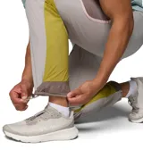 Pantalón cortavientos Columbia Challenger Windbreak Omni-Shield en color gris con paneles laterales en verde oliva y marrón, con dobladillo ajustable mediante cordón elástico.