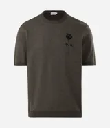 Remera de punto de algodón con textura jacquard, color verde oliva, de corte regular, cuello redondo y manga corta. Presenta un bordado de rosa en el frente.