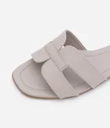 Sandalias planas Satinato de color tostado, con diseño de tiras cruzadas en forma de H en el empeine y puntera cuadrada.