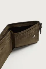 Cartera vertical para hombre fabricada en piel con acabado de serraje, en color verde militar. Dispone de un compartimento principal para billetes, seis posiciones internas para tarjetas y un compartimento para monedas con cierre de cremallera.