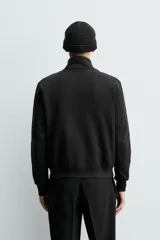 Sudadera de algodón color negro, de corte regular fit, con cuello alto, cierre frontal de cremallera bidireccional y bolsillos frontales de vivo.