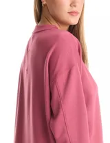 Buzo deportivo de cuello redondo, con hombros caídos y mangas largas con puños. Presenta costuras decorativas tipo pespunte en la parte frontal y en las mangas, con un diseño de ruedo recto y tajos laterales.