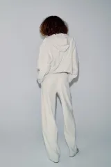 Pantalón de tiro medio color beige, de pierna ancha y corte recto. Cuenta con cintura elástica ajustable con cordones y bolsillos frontales.