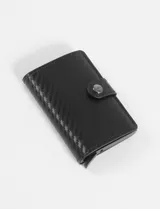 Tarjetero compacto de cuero sintético negro con textura de fibra de carbono y cierre a presión metálico.