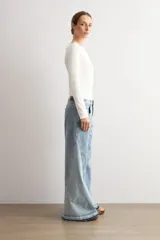 Jean wide leg de tiro medio con diseño bicolor, confeccionado en denim de lavado celeste con detalles de costuras y paneles en contraste. Cuenta con botamanga desflecada.