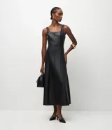Vestido midi negro de cuero sintético (poliuretano), con escote cuadrado, tirantes anchos y diseño ajustado con costuras verticales estructuradas.