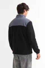 Campera de polar con cierre frontal completo, cuello alto y diseño bicolor en gris y negro. Cuenta con bolsillos laterales y puños elásticos.