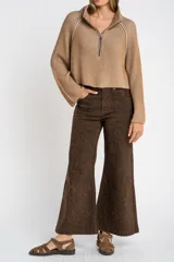 Sweater marrón de punto acanalado, con cuello alto, cierre frontal parcial con cremallera y manga larga.