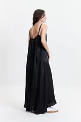 Vestido largo de silueta amplia y fluida, con breteles finos y escote redondeado. Presenta un diseño estampado con motivos geométricos en tonos bordó, beige y gris.