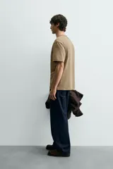 Camiseta de corte relajado con cuello redondo y manga corta, confeccionada en tejido de algodón liso.