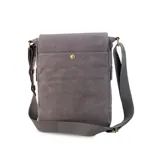 Morral de tela canvas gris con detalles en cuero sintético marrón. Cuenta con solapa frontal con cierre magnético, bolsillo tipo guantera bajo la solapa, división interna desmontable con velcro y correa larga regulable.