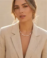 Collar de acero con baño de oro, compuesto por una alternancia de perlas de río y pequeñas cuentas doradas.