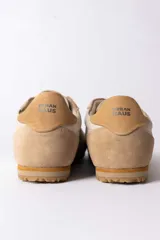 Championes urbanos de diseño retro, confeccionados en una combinación de gamuza y cuero texturizado en tonos beige y arena. Presentan cordones al tono y una suela dentada de goma en color caramelo.