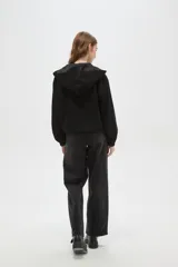 Campera de textura aterciopelada con cierre frontal completo, capucha y puños elásticos.