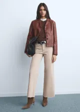 Jeans tiro alto estilo culotte de color beige claro, con diseño de pernera ancha, bajo deshilachado y cierre de cremallera y botón.