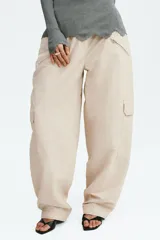 Pantalón cargo de nylon de corte oversized con leve efecto arrugado, cintura elástica fruncida, bolsillos con cierre en el frente y bolsillos con solapa en las piernas.