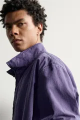 Cazadora relaxed fit de algodón en color violeta, con efecto lavado, cuello subido, cierre frontal con cremallera y bolsillos de vivo en la cadera.