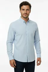 Camisa de lino y algodón color blanco, con cuello camisero, manga larga y cierre frontal de botones.