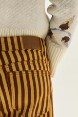 Jean de corte wide leg y tiro medio, con diseño de rayas verticales en tonos amarillo y marrón.