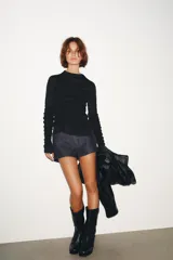 Top negro de cuello perkins y manga larga con frunces en el pecho y las mangas.