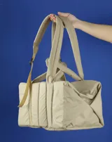 Bolso tipo tote color beige con diseño acolchado y doble asa de hombro.