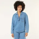 Camisa de jean de manga larga en tono azul medio, con cuello camisero, escote en V profundo y un bolsillo aplicado en el pecho.