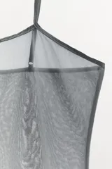 Top de tirantes finos ajustables, confeccionado en tejido de tul semitransparente con diseño texturizado, de corte recto.