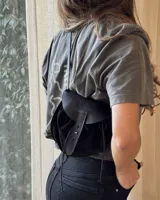 Bandolera negra de cuero gamuzado con solapa de cuero liso y cierre con tira de cuero.