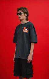 Remera de calce oversize color carbón, confeccionada en algodón premium. Presenta cuello redondo, mangas cortas y un pequeño estampado gráfico de Mickey Mouse en el pecho.