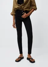Jeans skinny de tiro alto, confeccionados en tejido de algodón elástico. Presentan diseño de cinco bolsillos, cierre de cremallera con botón y trabillas en la cintura.