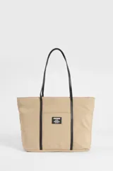 Cartera tipo shopper color beige con asas y detalles decorativos en cuero sintético negro. Cuenta con un bolsillo frontal exterior adornado con una etiqueta rectangular de la marca Symphorine.