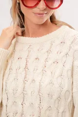 Sweater de punto color crema con cuello redondo y mangas largas.