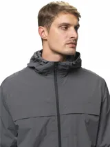 Campera rompevientos de nylon color gris, con capucha ajustable, cierre frontal completo, bolsillos laterales con cierre, puños elásticos y ruedo ajustable.