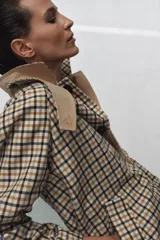 Trench reversible de Zara Woman Collection con diseño de cuadros en tonos beige, negro y tostado. Cuenta con cuello de solapa, cierre frontal con botones oscuros y bolsillos delanteros diagonales.