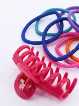 Set de accesorios para el cabello compuesto por una pinza de plástico fucsia y diez coleros elásticos en colores surtidos.
