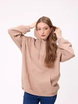 Canguro negro de corte holgado con capucha y cordones ajustables. Presenta un bolsillo frontal tipo canguro y un pequeño logo bordado en el pecho.