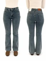 Jean de corte bootcut en color azul medio, con tiro medio y cierre frontal con botón y cremallera. Presenta diseño clásico de cinco bolsillos y costuras reforzadas.